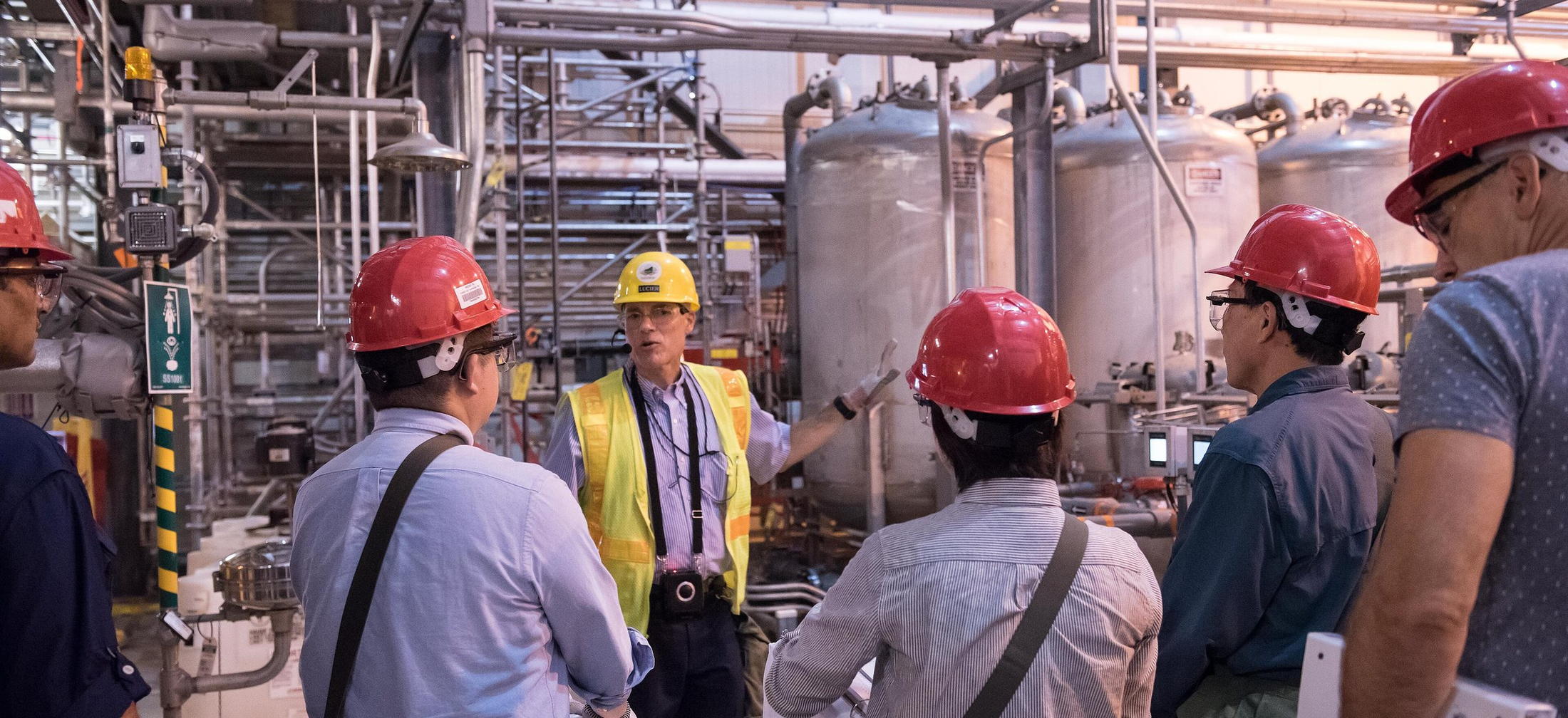 Engineers reviewing equipment in an operating industrial facility